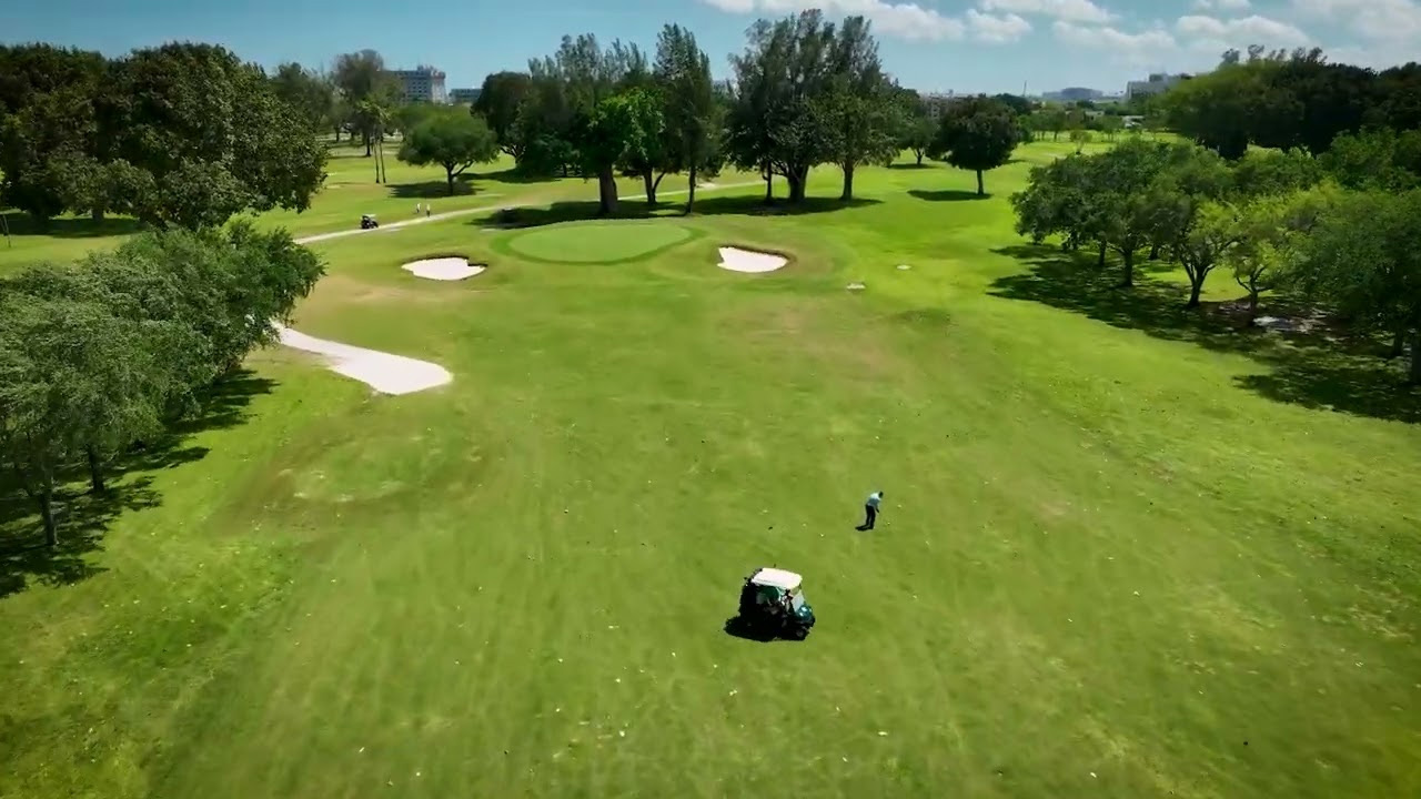 Aerial view of Miami Springs Golf & Country Club, Hole 13 — lush green fairways with canal